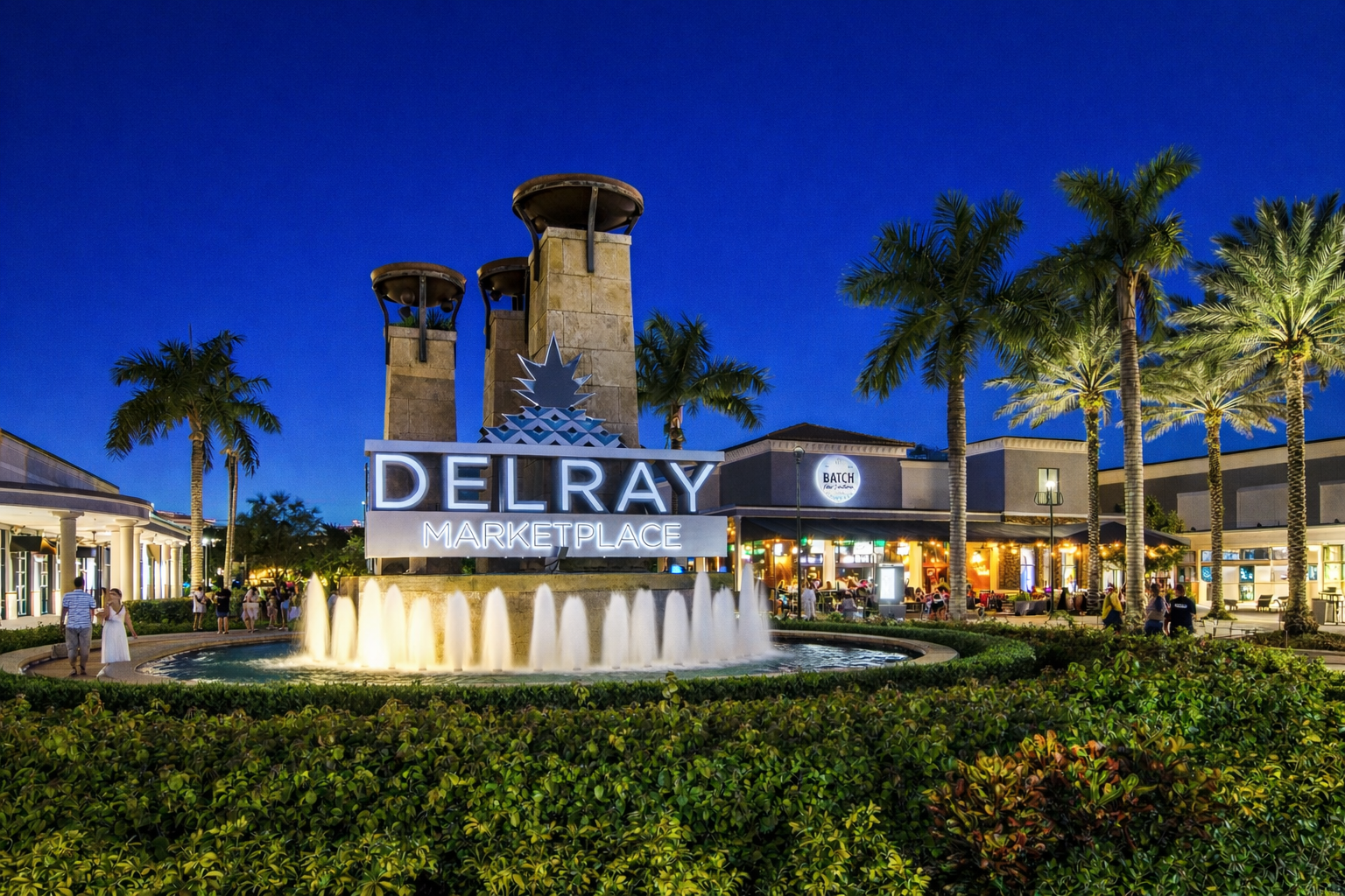 Delray Marketplace at night with fountain and palm trees