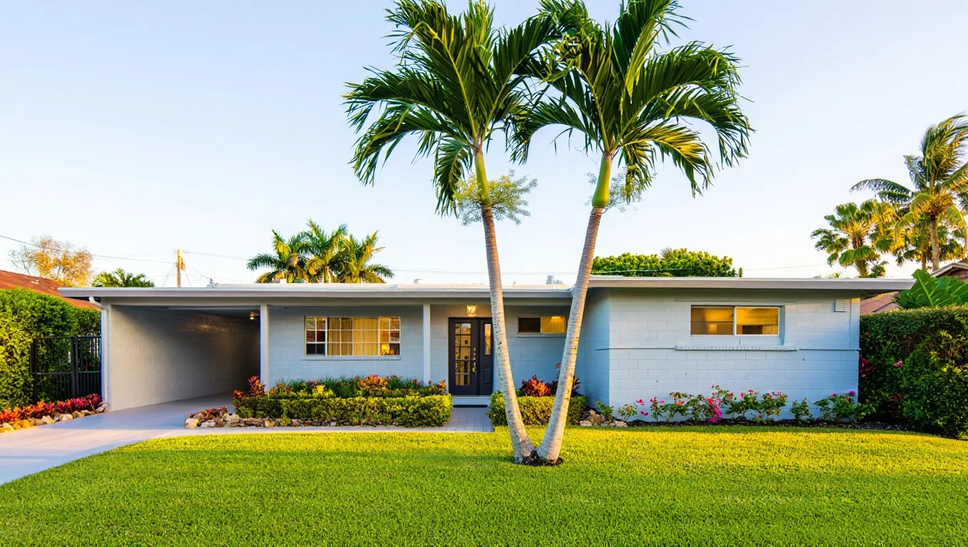 Freshly painted concrete block ranch home in Boynton Beach with palm trees and manicured lawn